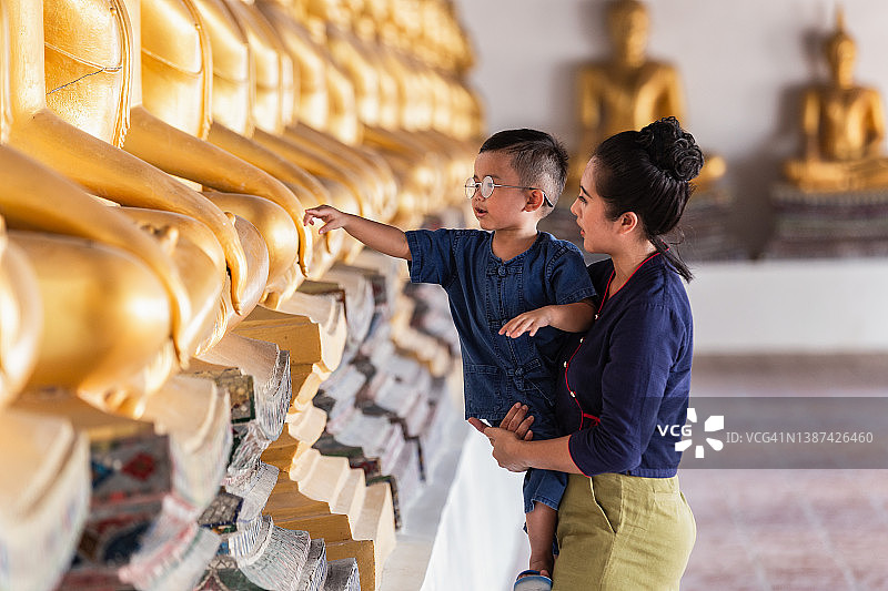 在泰国大城府普泰沙湾寺，母子正在为佛像祈祷图片素材