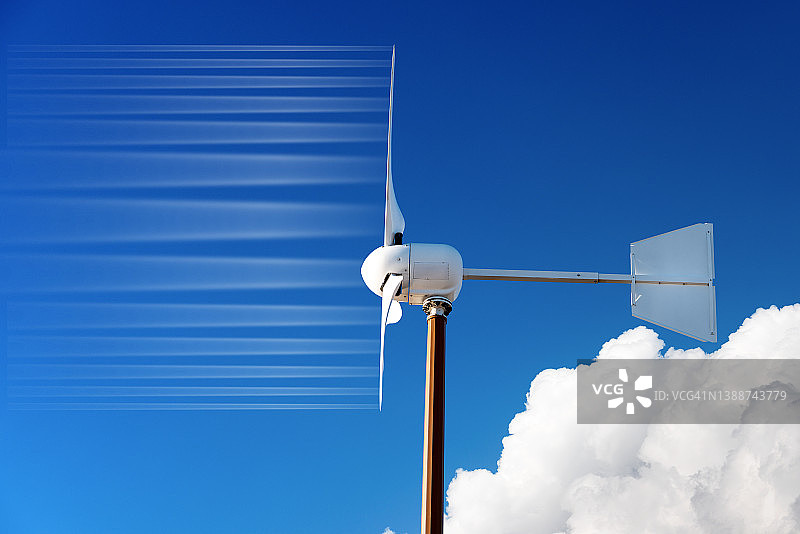一个小型风力涡轮机的特写，对着清澈的蓝天和云彩图片素材