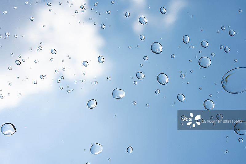 完整的框架纹理形成的气泡和水滴对蓝天背景。图片素材