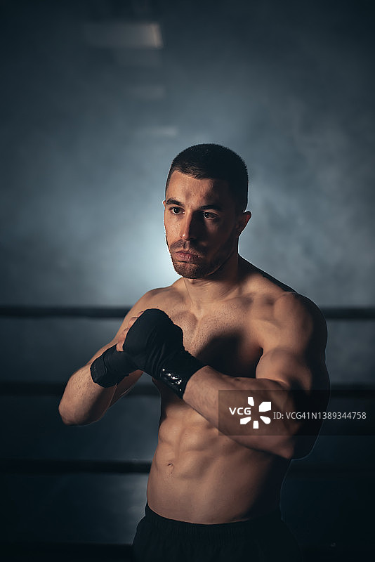 拳击手，戴着绷带在拳击台上摆姿势。健身和拳击概念。高质量的照片图片素材