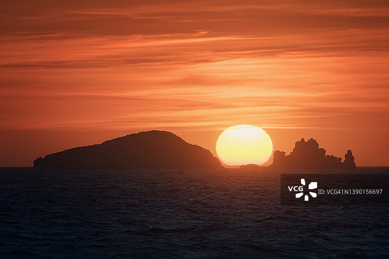 伊比沙岛一些小岛之间的巨大太阳的日落，风景摄影图片素材