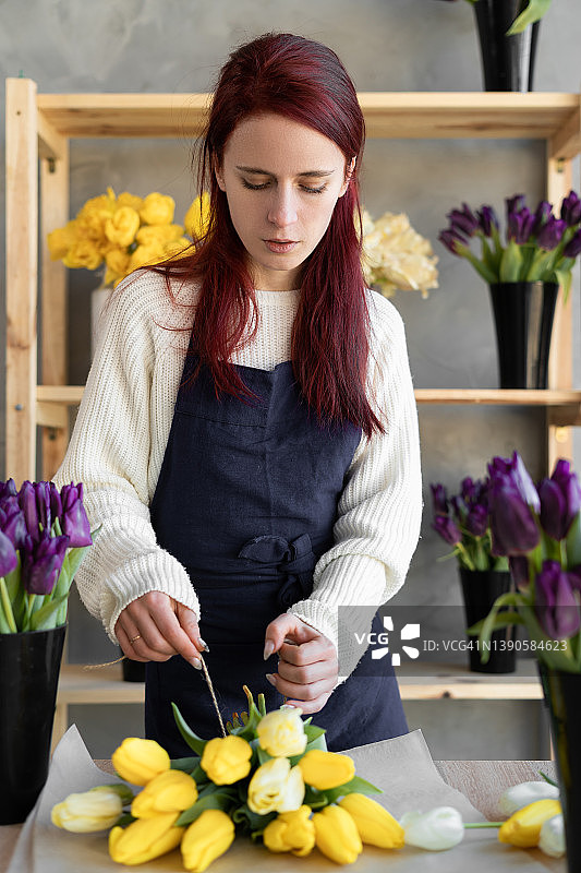 白人女花商制作了一束郁金香。花店的工作场所。为爱人准备礼物。图片素材