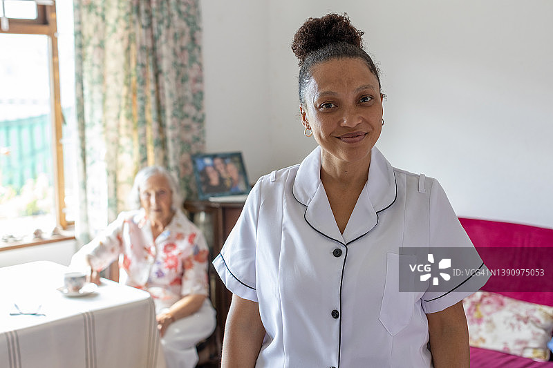 一名社区护士在对一位年长的女士进行家访时的肖像图片素材