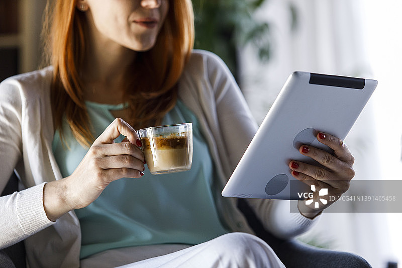 选择焦点的女人享受咖啡和使用数码平板电脑图片素材