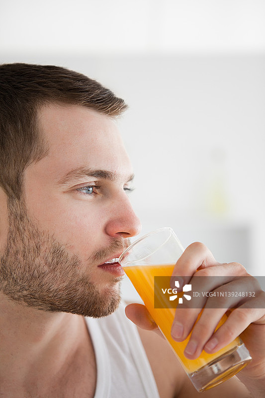 一个男人喝橙汁的特写图片素材