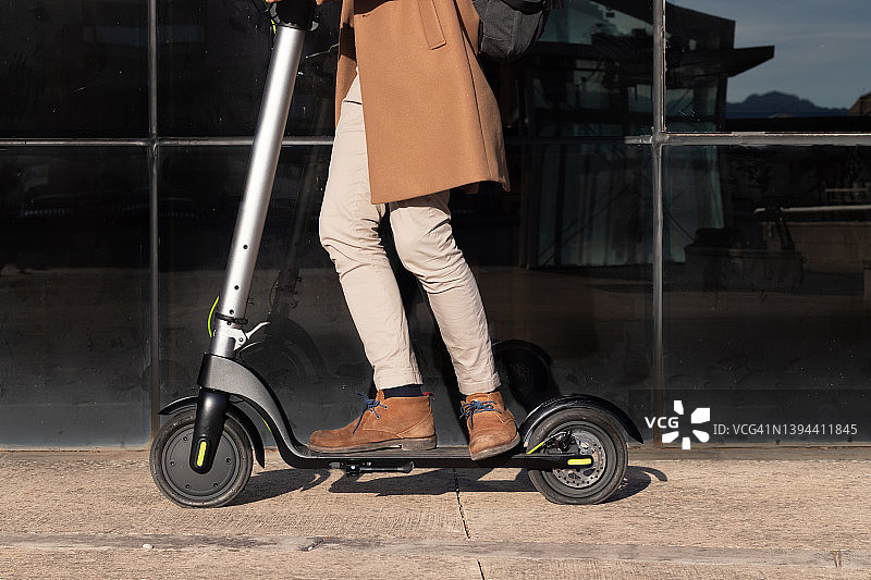 在市中心的金融区，人们骑电动滑板车作为替代和生态友好的交通工具图片素材