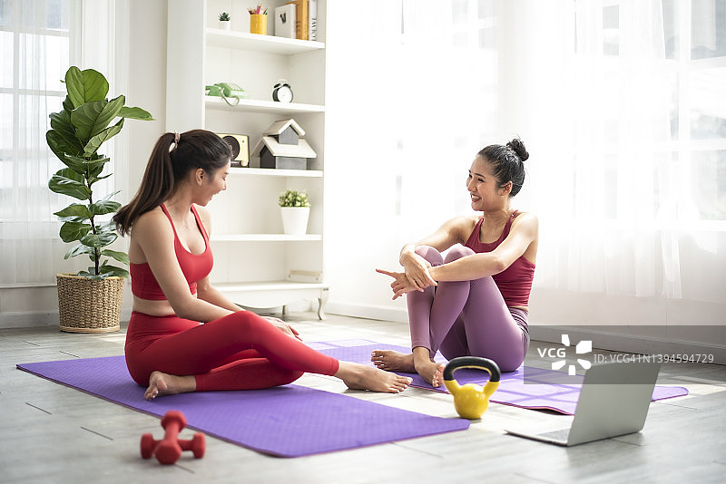 两个亚洲女人在练习瑜伽前聊天放松。图片素材