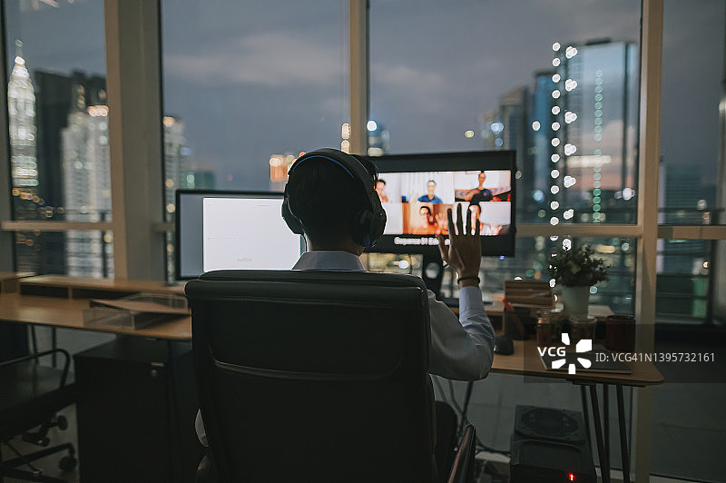 亚洲印度男性白领视频电话工作到很晚，在办公室里独自在低光图片素材