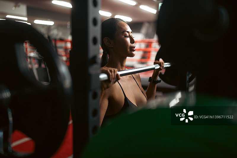 健身的女人在健身房使用举重和训练器材进行肌肉训练图片素材