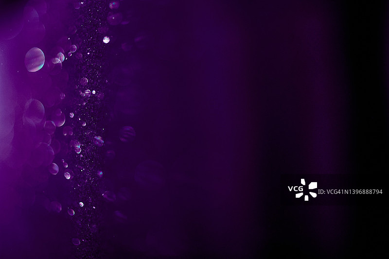 美丽神奇的紫色背景，小圆尘埃颗粒在光线中闪闪发光图片素材
