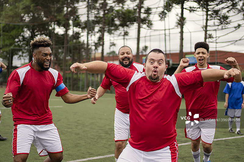 患有唐氏综合症的足球运动员在友谊赛中庆祝进球图片素材