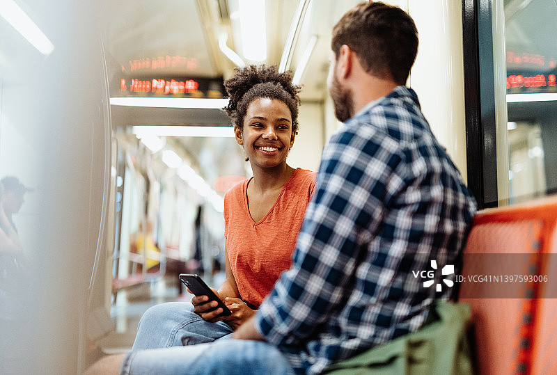 乘坐地铁上下班，人们在路上聊天，微笑图片素材