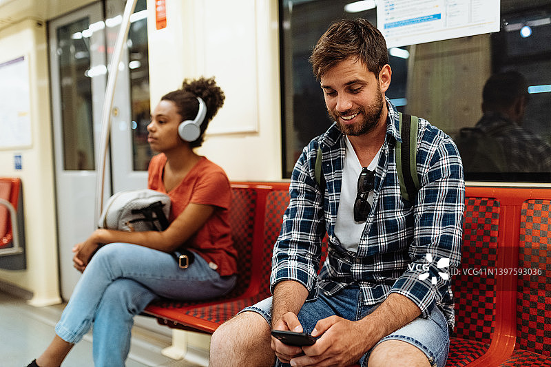 游客和背包客在城市乘坐地铁旅行，使用手机进行GPS导航图片素材