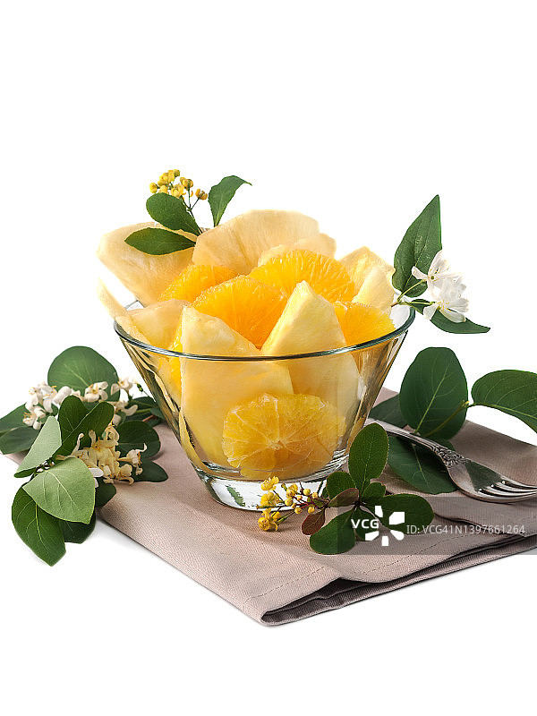 橙子和菠萝切片放在玻璃碗中，白色背景上分离图片素材