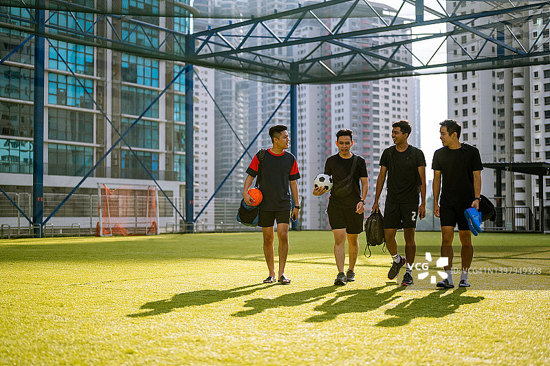 亚洲男足球运动员微笑着走进运动场进行训练图片素材