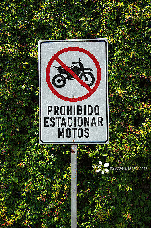 城市街道上的西班牙语指示牌，上面写着“禁止停放摩托车”图片素材