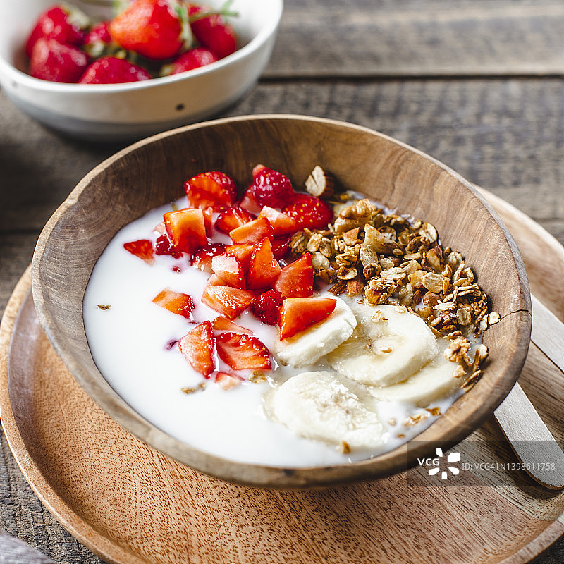 健康食品的概念。自制酸奶和草莓格兰诺拉麦片，在木桌上俯瞰图片素材