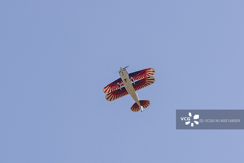 仰望蓝天的白色双翼飞机，翅膀上有红色条纹图片素材