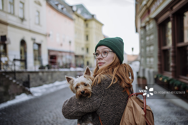 在城市里背着宠物狗背包的女人图片素材