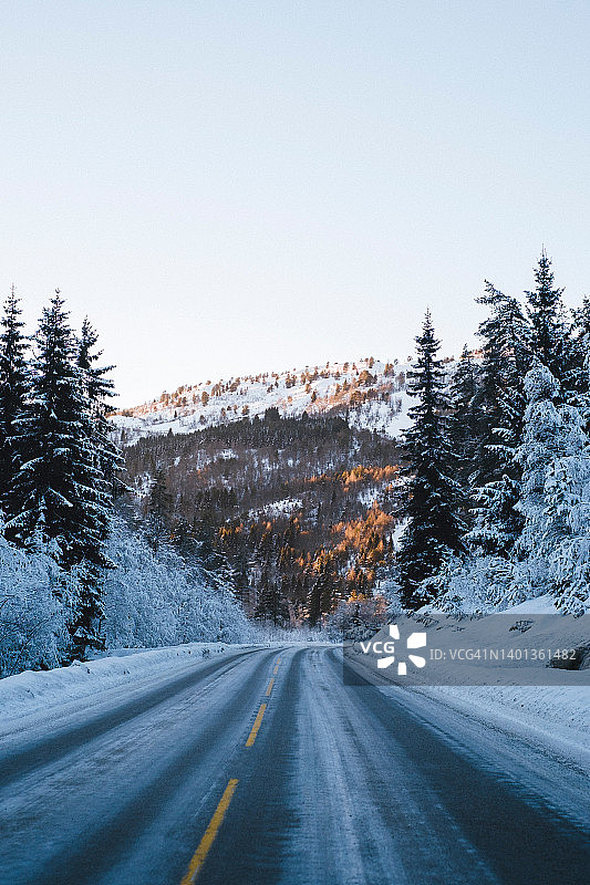 道路通过一个寒冷的冬季景观。Sogndal,挪威。图片素材