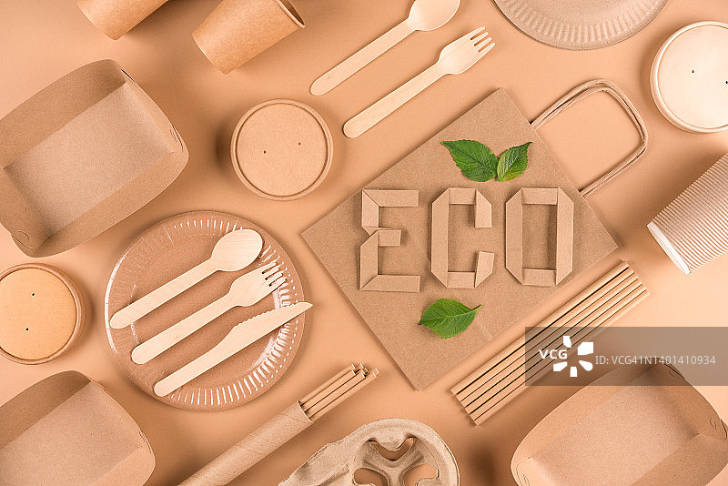 平面铺设图像与纸器皿，木制餐具和纸字ECO在浅棕色的背景。街头食品可持续纸质包装，零浪费包装理念图片素材
