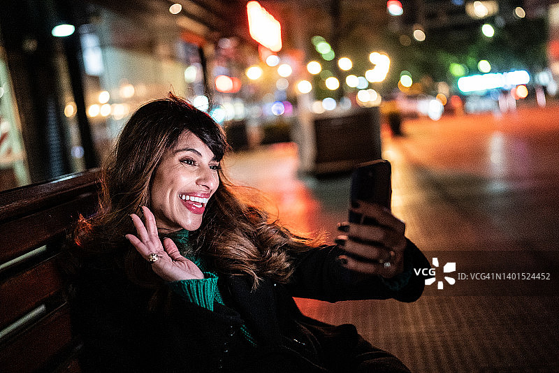 年轻女子在街上用手机进行视频通话图片素材