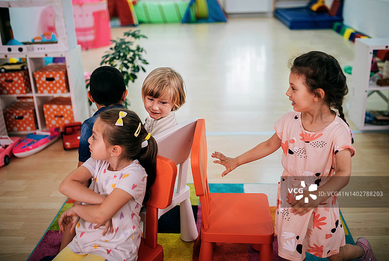 微笑的老师和孩子在幼儿园说话和玩耍图片素材