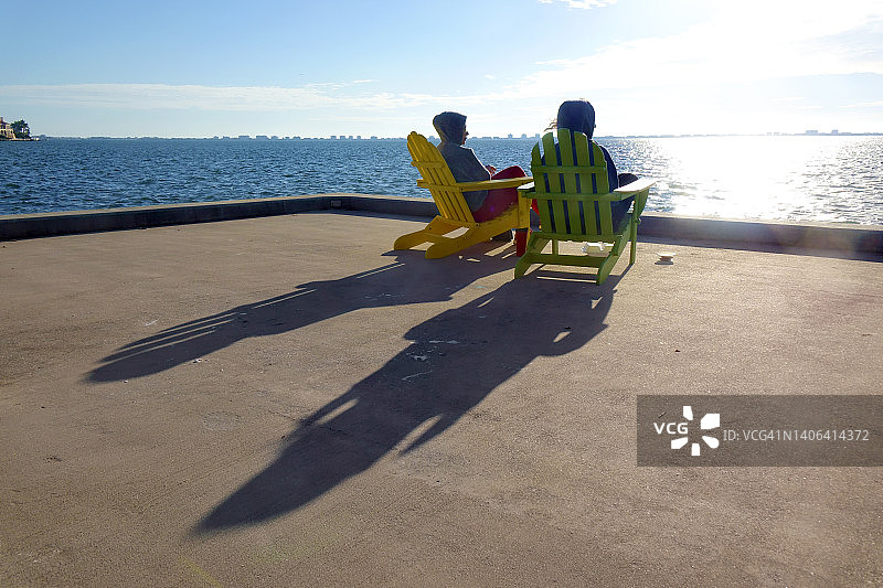 两个幸福的女人坐在海边看风景图片素材