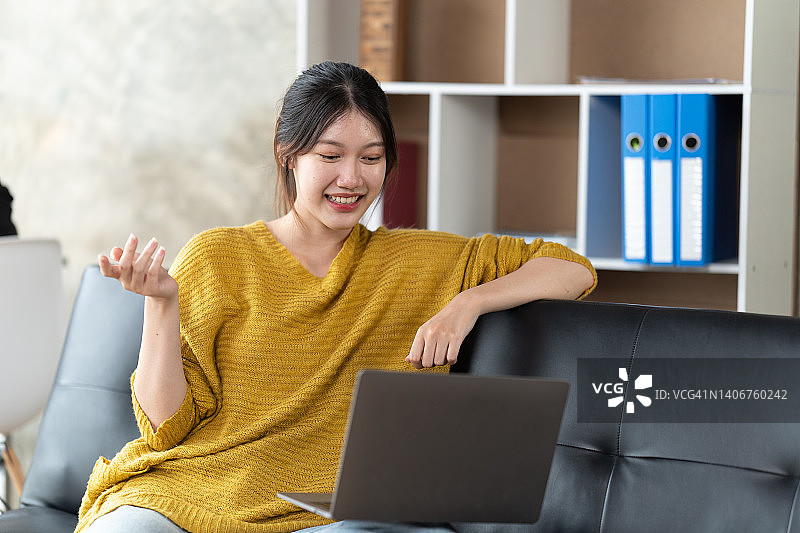 一位在办公室用笔记本电脑工作的亚洲女性。商业财务和在家工作的概念。图片素材