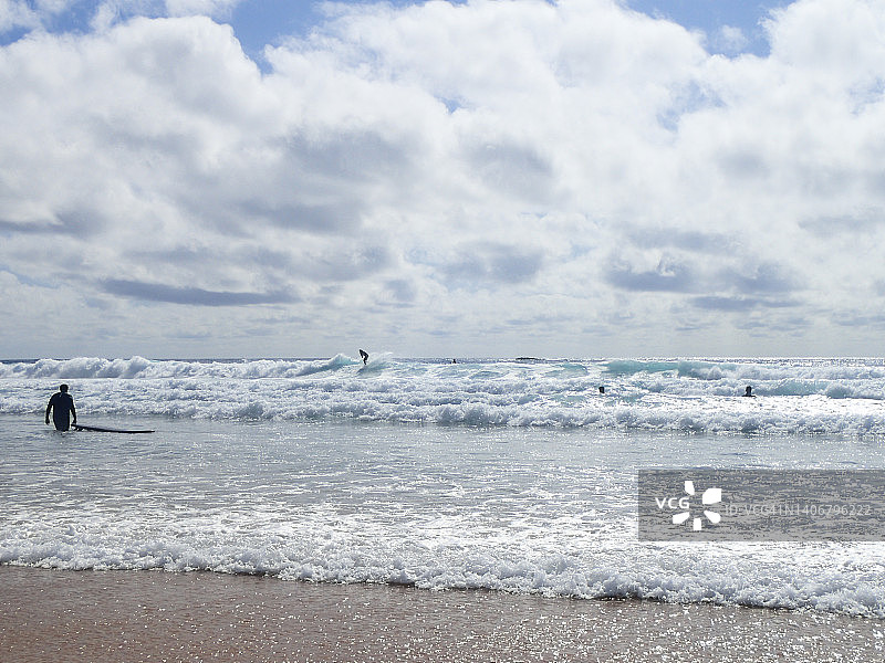 冲浪者。葡萄牙阿尔加维的阿马多海滩图片素材