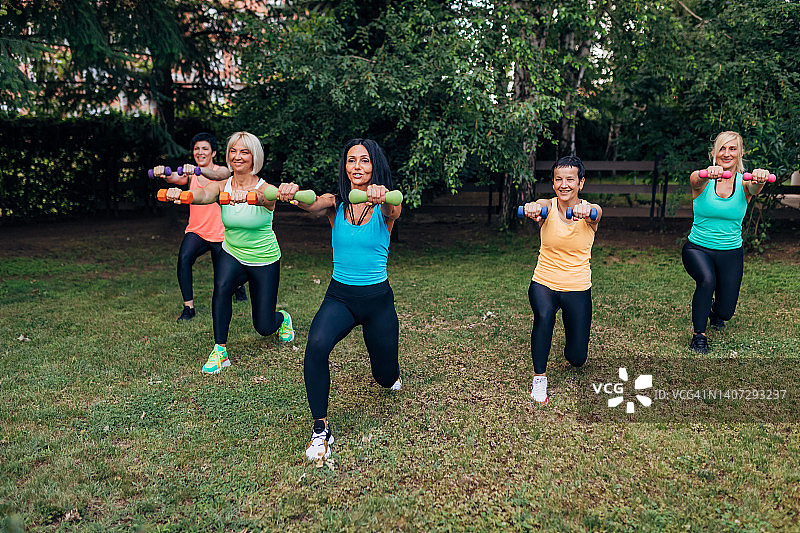 一名健身教练向一小群女性展示向前迈一步的动作图片素材