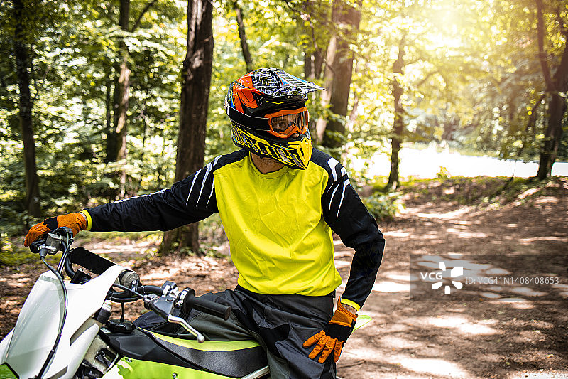 肖像的专业越野摩托车骑手准备摩托车穿越森林比赛。图片素材