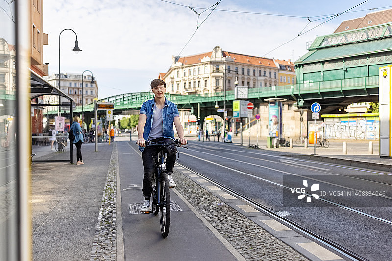 年轻人在城市街道上骑自行车图片素材