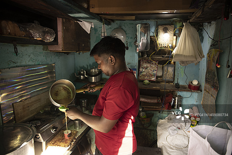 一个正在煮茶的年轻人的侧面图图片素材