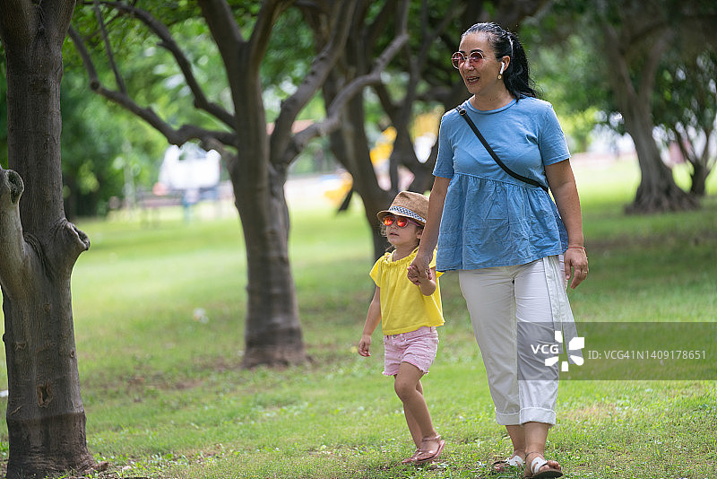 母亲和小女儿在公园散步的照片图片素材
