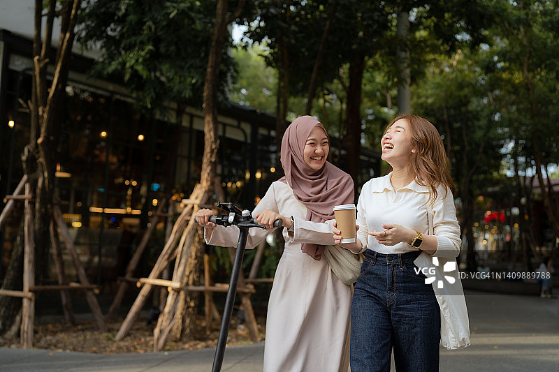 亚洲女商人在公园喝咖啡休息时聊天。图片素材