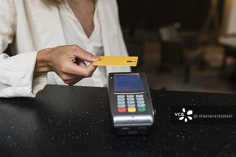一位女商人在餐厅用信用卡付款图片素材