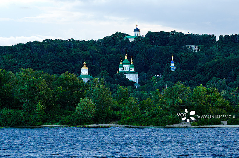 基辅著名的山丘在蓝天的映衬下，令人惊叹的日落景观。圆顶的圣乔治大教堂和古老的维杜比奇修道院的迈克尔大教堂在老树之上。基辅图片素材