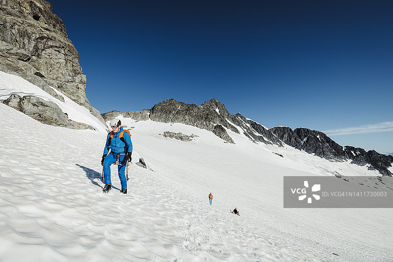 在不列颠哥伦比亚省，一名男子走过一座巨大的冰川图片素材