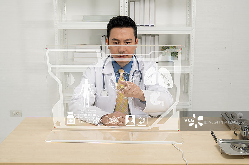 医生穿着白色的医疗制服和听诊器在清晰的屏幕上工作图片素材