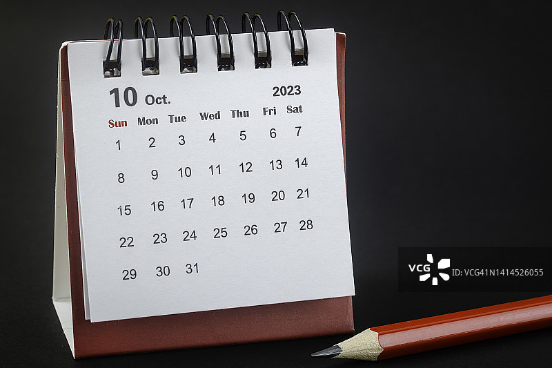 2023年10月是组织者计划的月份，红铅笔黑色背景。图片素材
