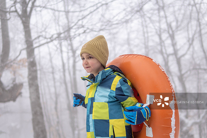 在雪中携带管子的男孩图片素材