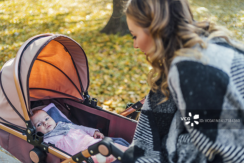 母亲和女婴在秋天的公园图片素材