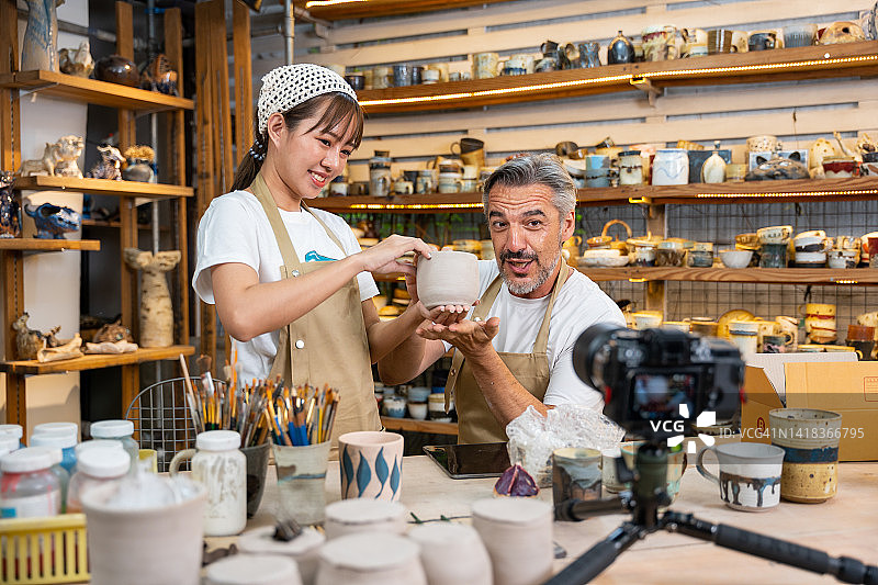 陶工们正在陶艺工作室进行在线直播，竞拍手工陶瓷制品图片素材
