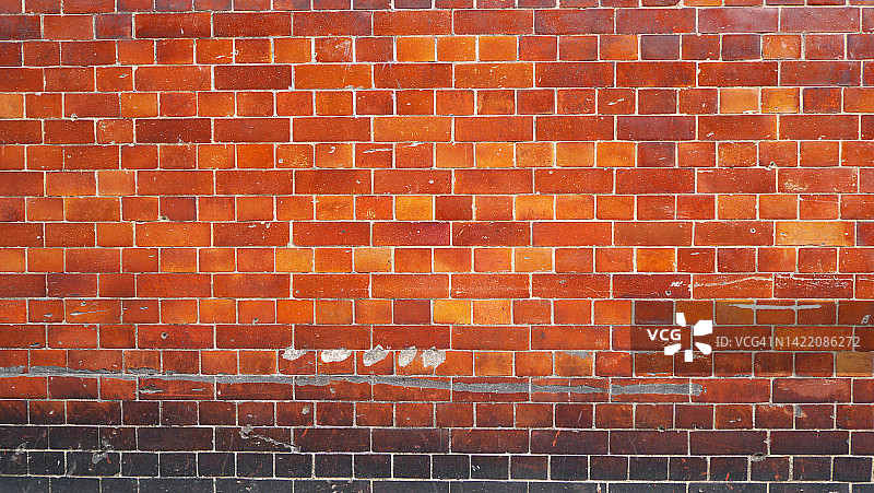 在伦敦，英格兰，英国的红色，橙色和黄色风化砖墙图片素材