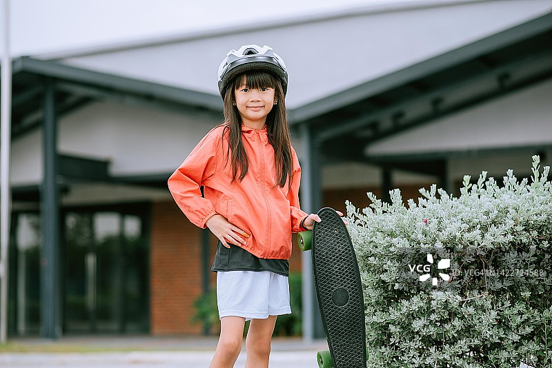 戴着滑板和头盔的亚洲小女孩图片素材