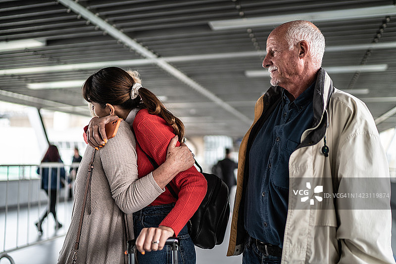 孙女在地铁站或机场离开并拥抱爷爷奶奶图片素材