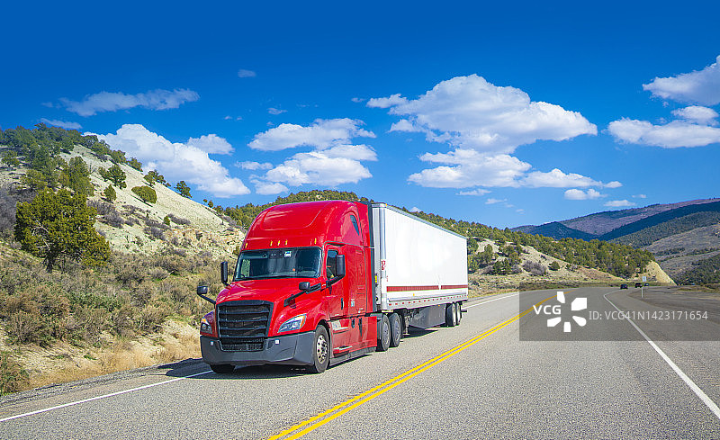 美国由卡车运输-在美国犹他州的白色和红色的长拖车图片素材
