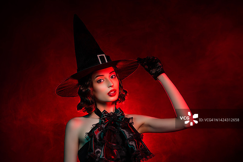 照片的恐怖魔鬼神秘女士穿黑色连衣裙手臂手哥特式头饰孤立的深红色烟色背景图片素材