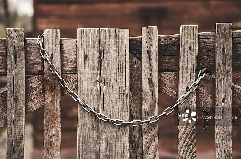 生锈的钢链。木头背景上的一条旧铁链。图片素材